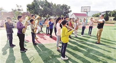 今年以来,南安市大力推进“和谐村”创建工作。码头镇诗南村为村民免费开设钢琴、管乐、南音等公益课堂,打造乡村音乐文化,在丰富村民文化生活的同时,促进形成和谐文明的乡村新风尚。 右图为南安市诗南村诗南小学校长陈小富在指挥学校管乐团排练。 (宋为伟 摄)