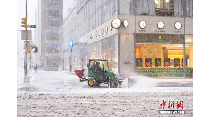 当地时间2月1日,纽约曼哈顿,一名工作人员驾驶除雪车在人行道上清扫积雪。受“东北风暴”(Nor’easter)影响,纽约市从前一日晚间开始降雪。 中新社记者 王帆 摄