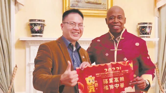 亚当斯与东南网美国站代表朱立业一起展示“福星高照 福佑中华”的“福”文化祝福语。明明 摄